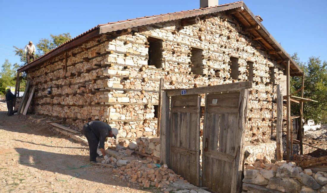 Düğmeli taş evin temel ve duvar örme aşaması, işçiler çalışıyor